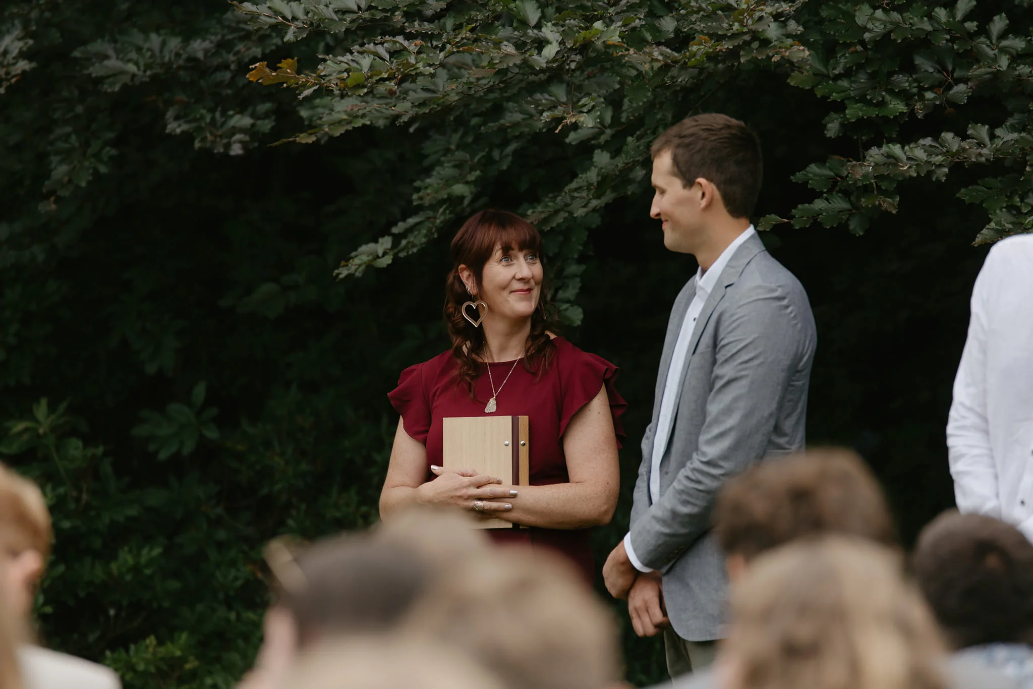 Hayley L'Huillier during a wedding ceremony, warm and attentive, New Zealand garden setting