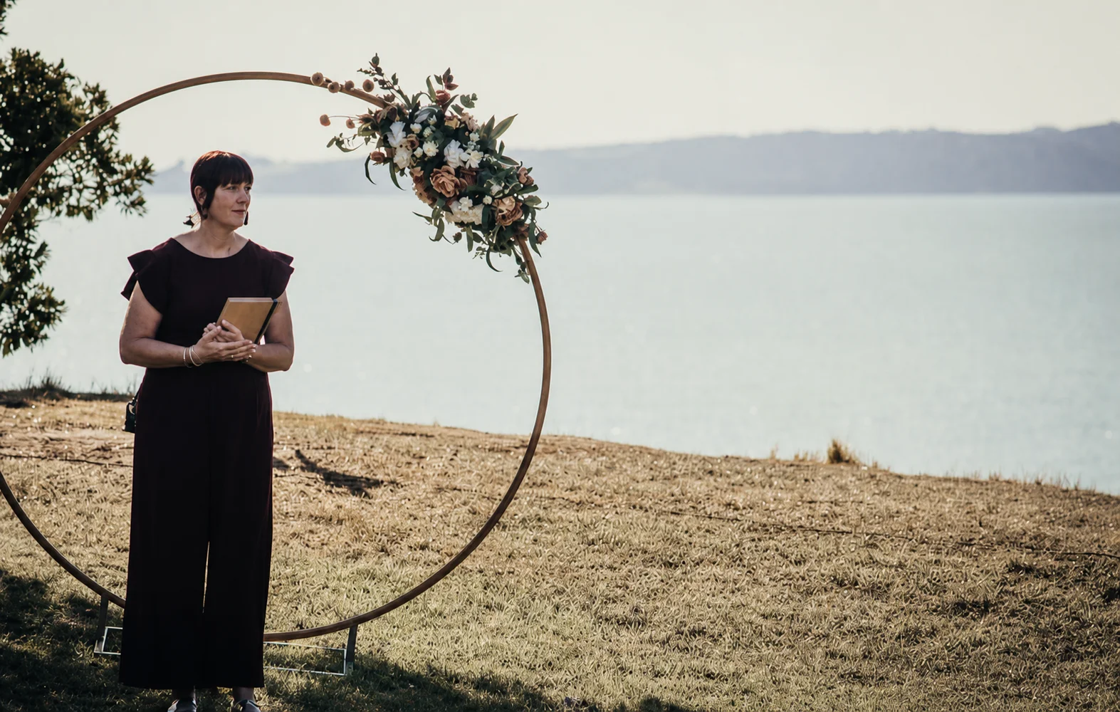 A couple during their wedding ceremony in a Canterbury garden at golden hour, native New Zealand plantings framing the scene