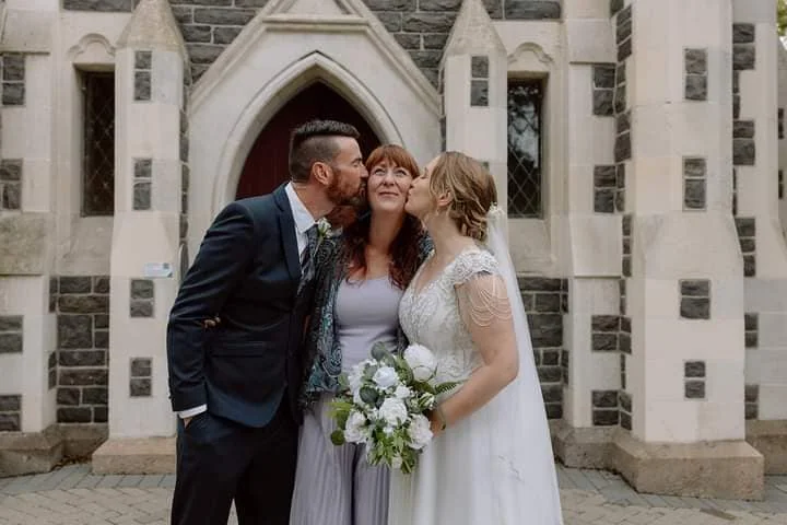 A couple during their civil union ceremony, signing the register in a Canterbury garden setting