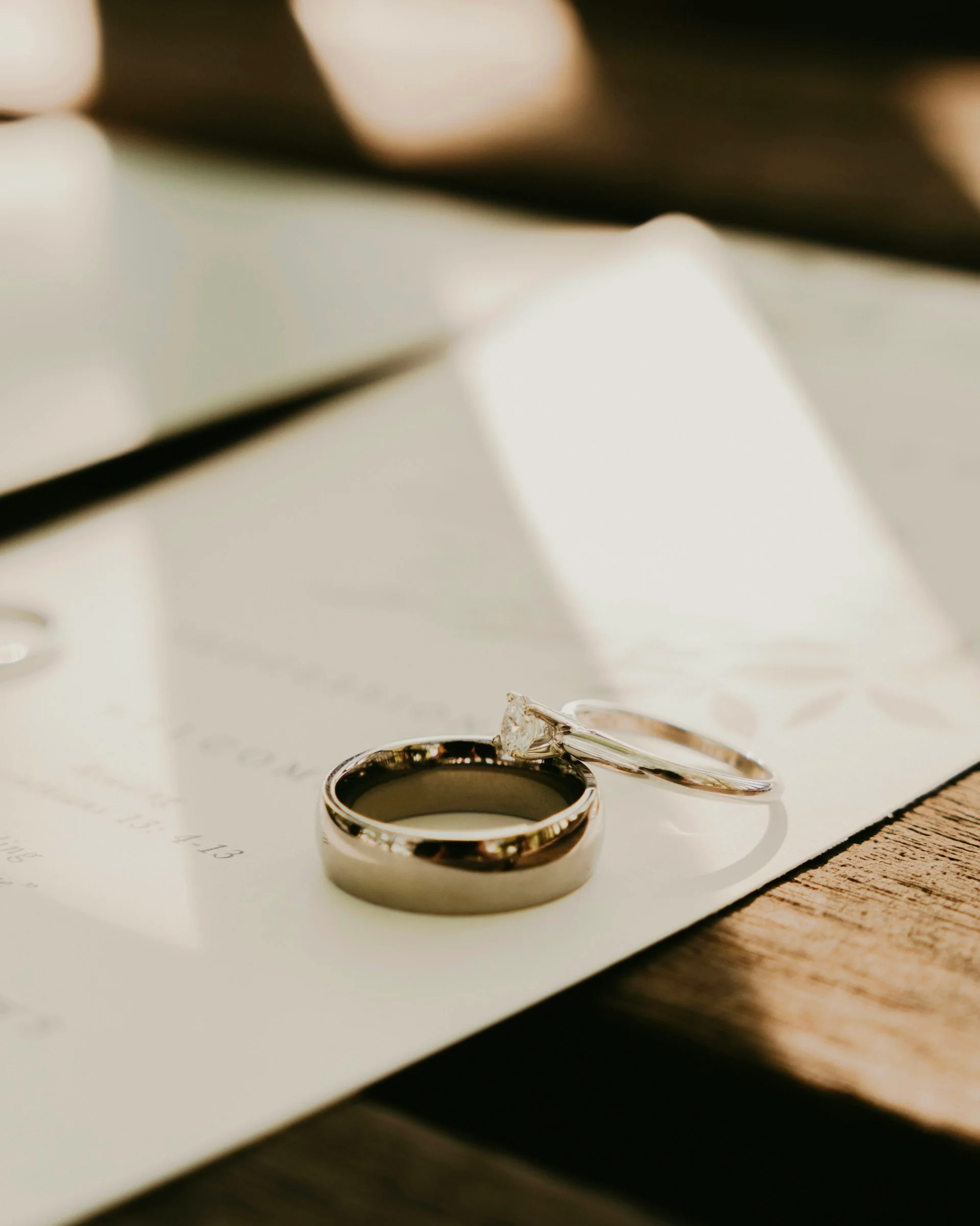 A couple signing their marriage register with their celebrant present, ceremony stationery visible
